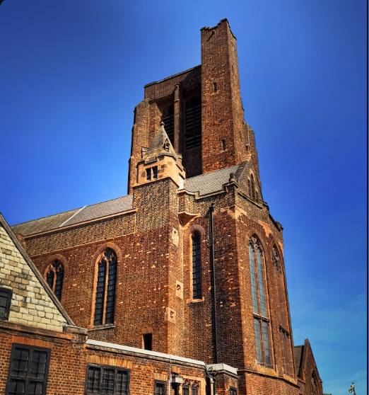 Brick church tower against a deep blue sky